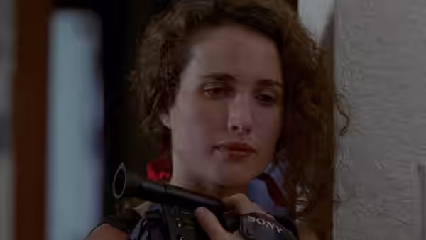 a woman with curly hair holds a video camera