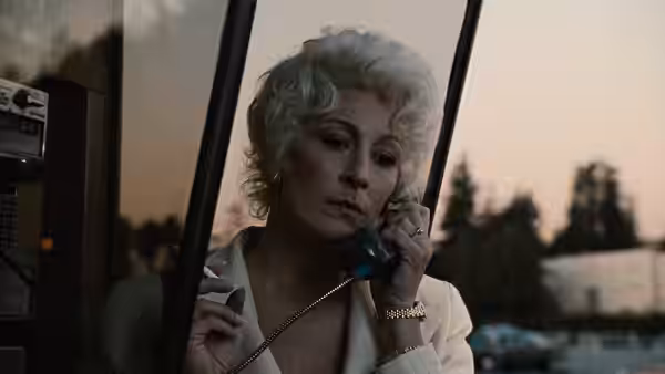 Lilly Dillon (Anjelica Huston) speaking on a payphone at dusk