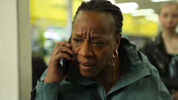 A woman speaking on a mobile phone with a concerned expression in a store