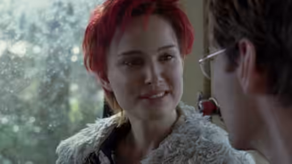 Alice (Natalie Portman) smiles at Dan (Jude Law) beside a window