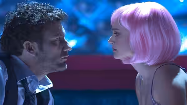 Larry (Clive Owen) and Alice (Natalie Portman), wearing a pink wig, face each other in a club