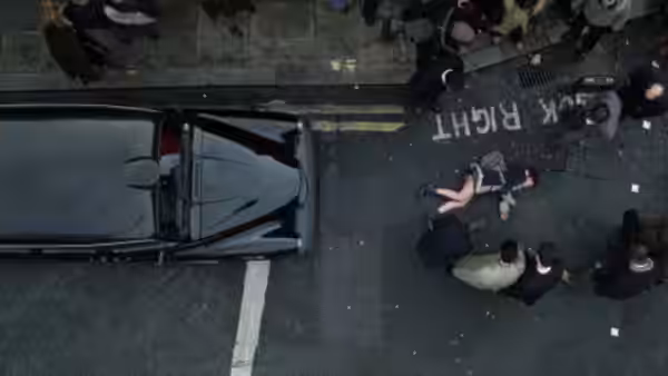 Alice (Natalie Portman) lies in the street as bystanders gather beside a car