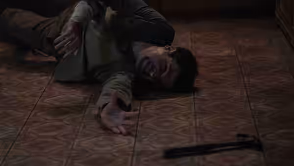 Blake (Christopher Abbott) lying injured on a patterned floor