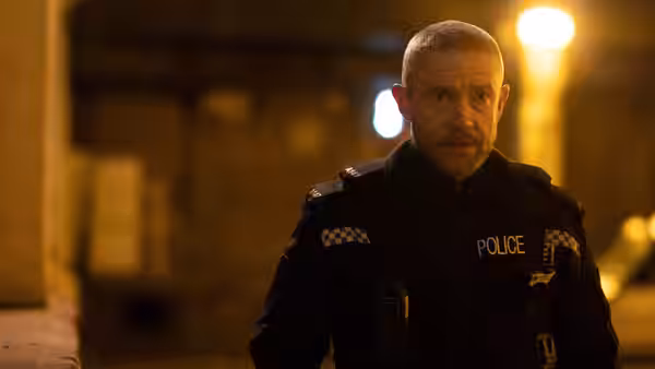 Chris Carson (Martin Freeman) walking on a quiet street under streetlights at night