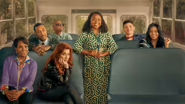 Teachers and staff seated on a bus with one woman standing in the aisle