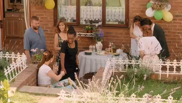 A group of people gathered around a table at a garden party