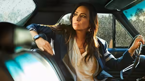 Sam Fox (Pamela Adlon) seated at the wheel of a car