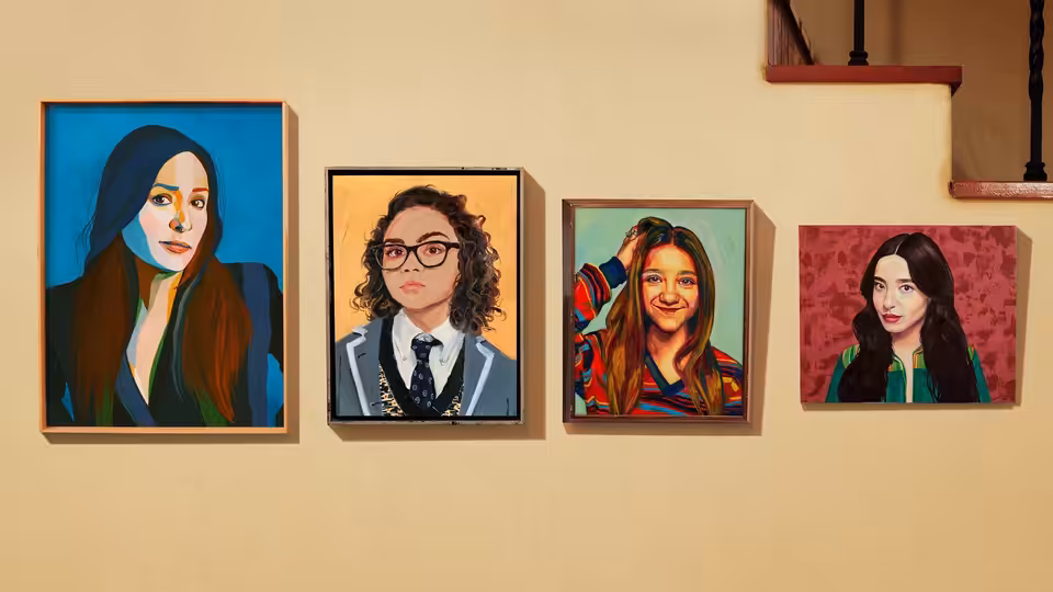 four framed portraits of women displayed on a beige wall