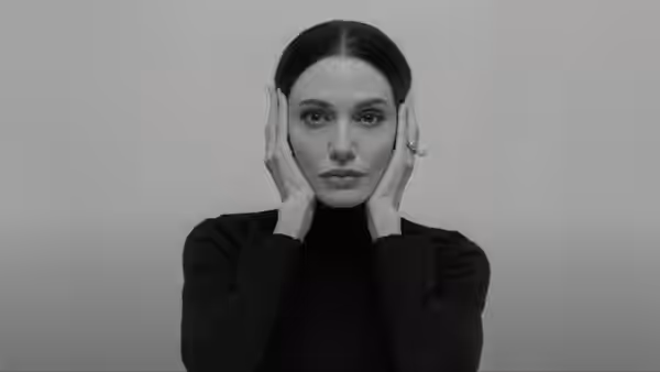 Maria Callas (Angelina Jolie) rests her hands on her cheeks in close-up