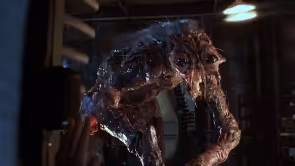 Seth Brundle's grotesque mutated form standing in the laboratory