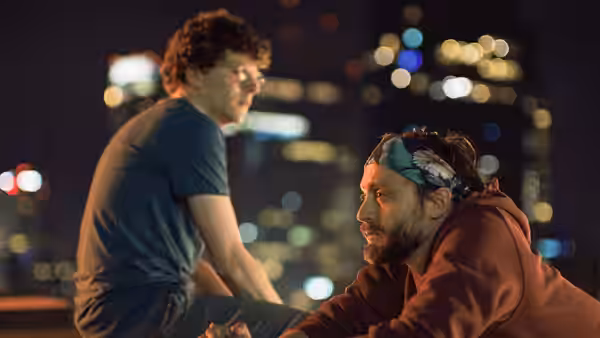 David Kaplan (Jesse Eisenberg) and Benji Kaplan (Kieran Culkin) on a rooftop at night