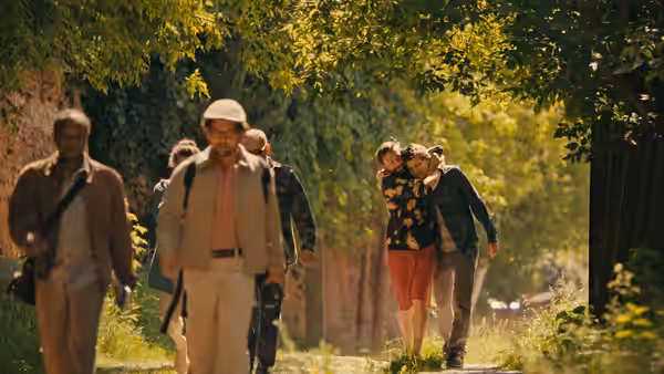 Group of people walking along a tree-lined path