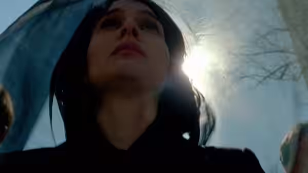 Jackie Kennedy (Natalie Portman) looks upward beneath a dark veil in bright daylight
