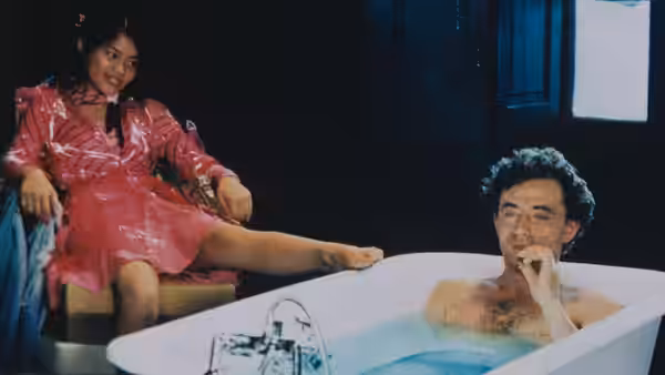 Alba sits beside Gorodish relaxing in a white bathtub