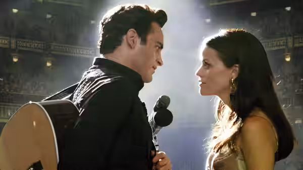 John R. Cash (Joaquin Phoenix) and June Carter (Reese Witherspoon) on stage with microphone