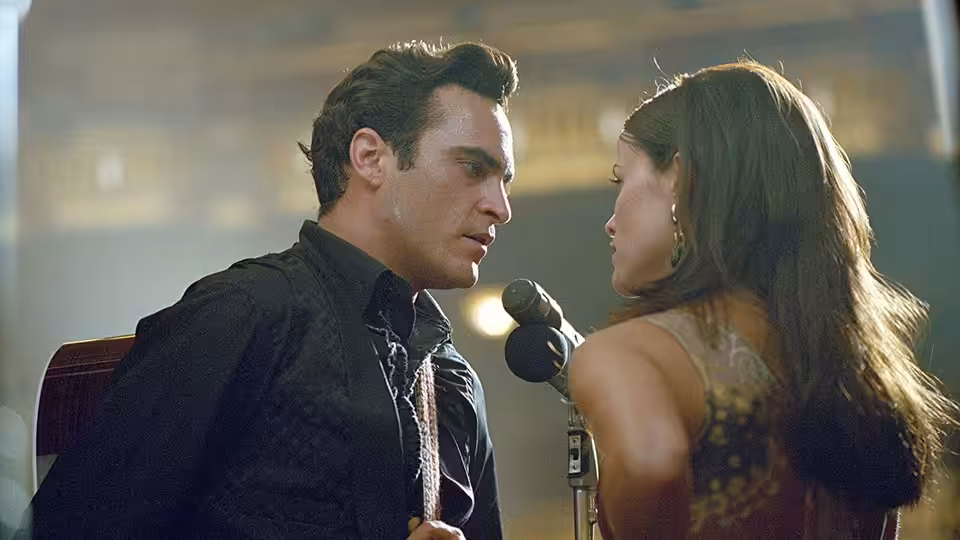 John R. Cash (Joaquin Phoenix) facing June Carter (Reese Witherspoon) at a microphone