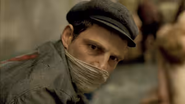 Saul Ausländer (Géza Röhrig) with mouth bound wearing a cap