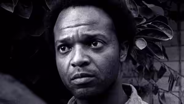 man with wide eyes and furrowed brow gazing to one side