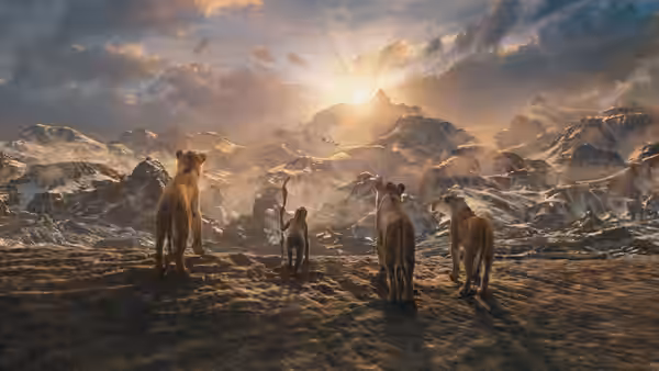 pride of lions overlooking a vast snowy mountain landscape at sunset