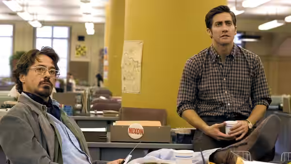 Paul Avery (Robert Downey Jr.) and Robert Graysmith (Jake Gyllenhaal) seated in an office